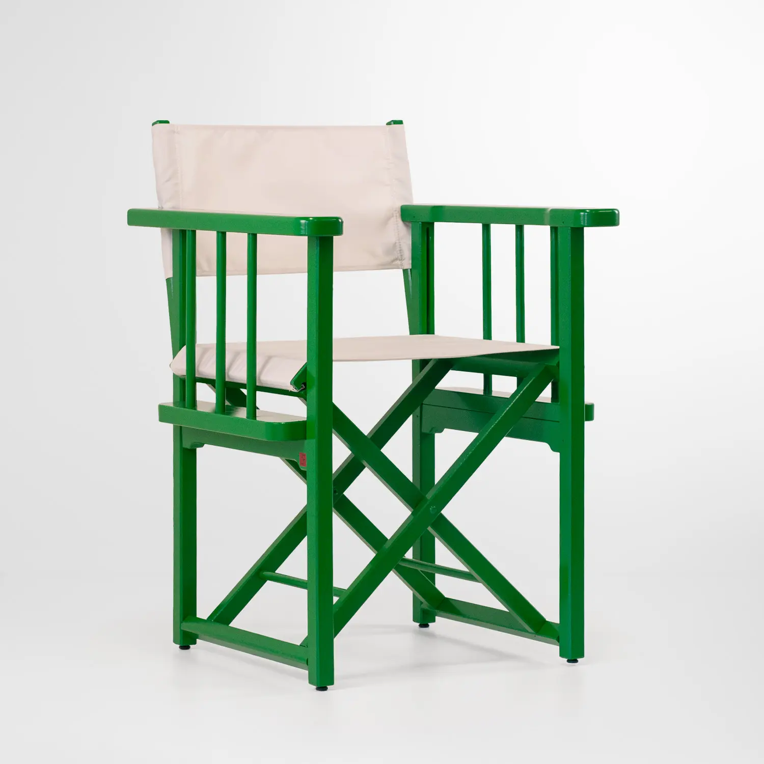 Fauteuil pliant type chaise de réalisateur, structure vert forêt et toile écrue pour l’assise et le dossier, sur fond blanc.