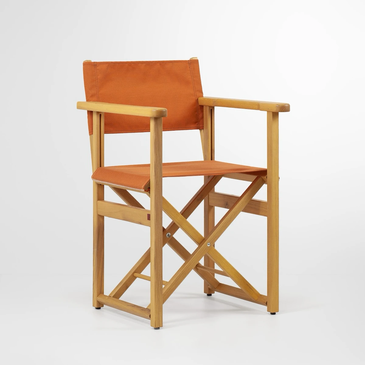Chaise de metteur en scène pliante en bois clair, toile orange pour l’assise et le dossier, vue trois-quarts sur fond blanc.